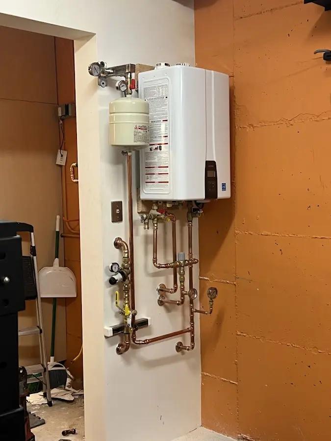 Plumbing technician inspecting water heater connections in Whittier